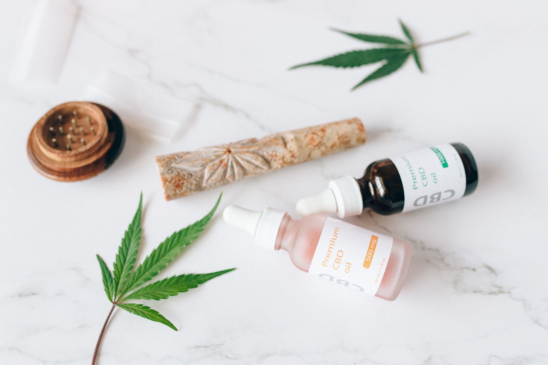 Feuilles de cannabis près de flacons compte-gouttes